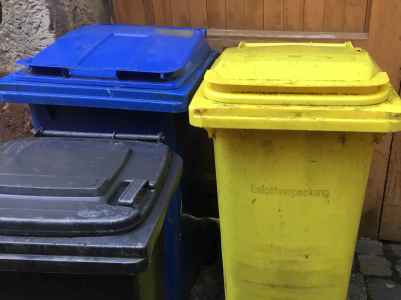 Symbolbild "Abfall und Müll". Zu sehen sind drei unterschiedliche Mülltonnen.