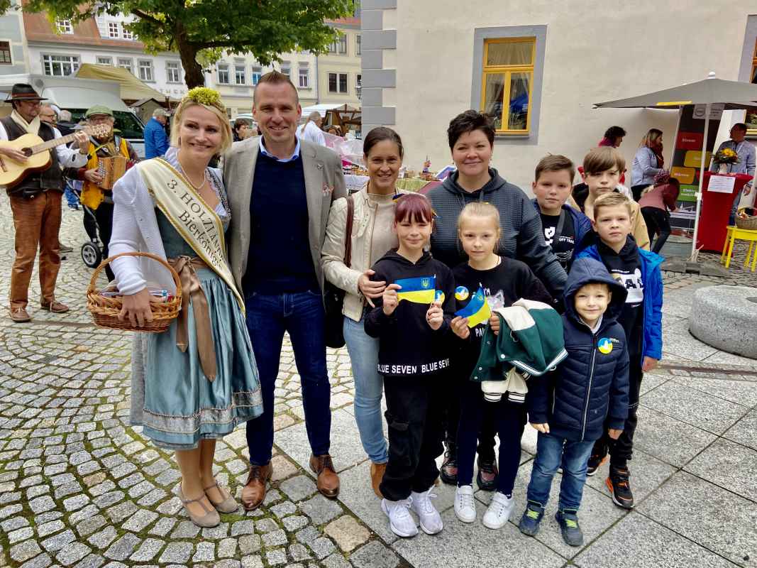 Die Holzländer Bierkönigin, der Eisenberger Bürgermeister und ukrainische Kinder bei der Eröffnung des Eisenberger Landmarktes.